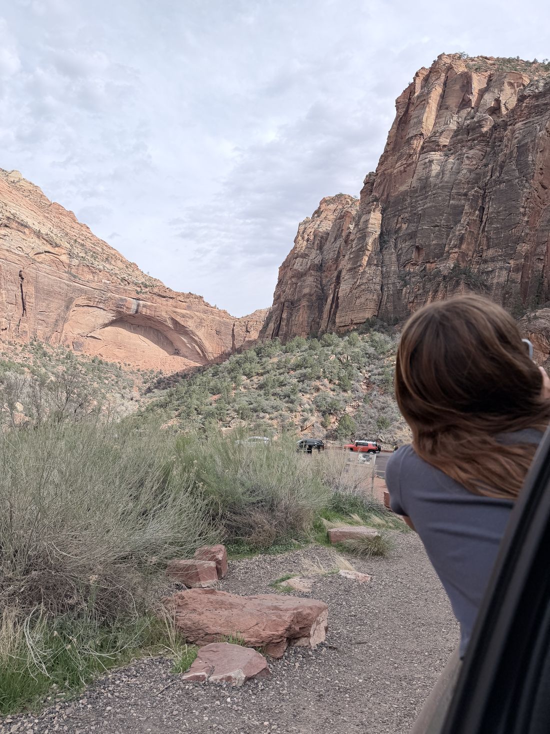 Cars parked at a pullout on the Zion&ndash;Mt. Carmel Highway with the Great Arch across the canyon.